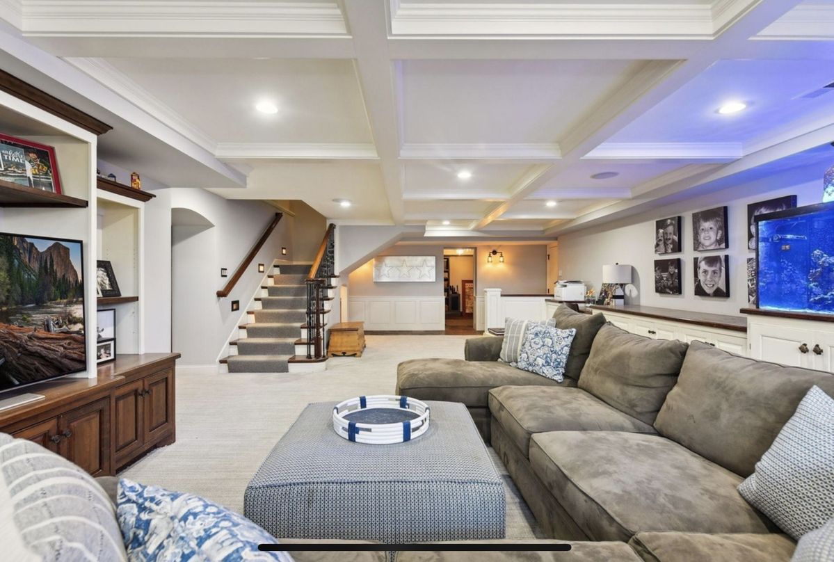 Finished luxury basement lounge with pool table, stone fireplace and reclaimed wood wall