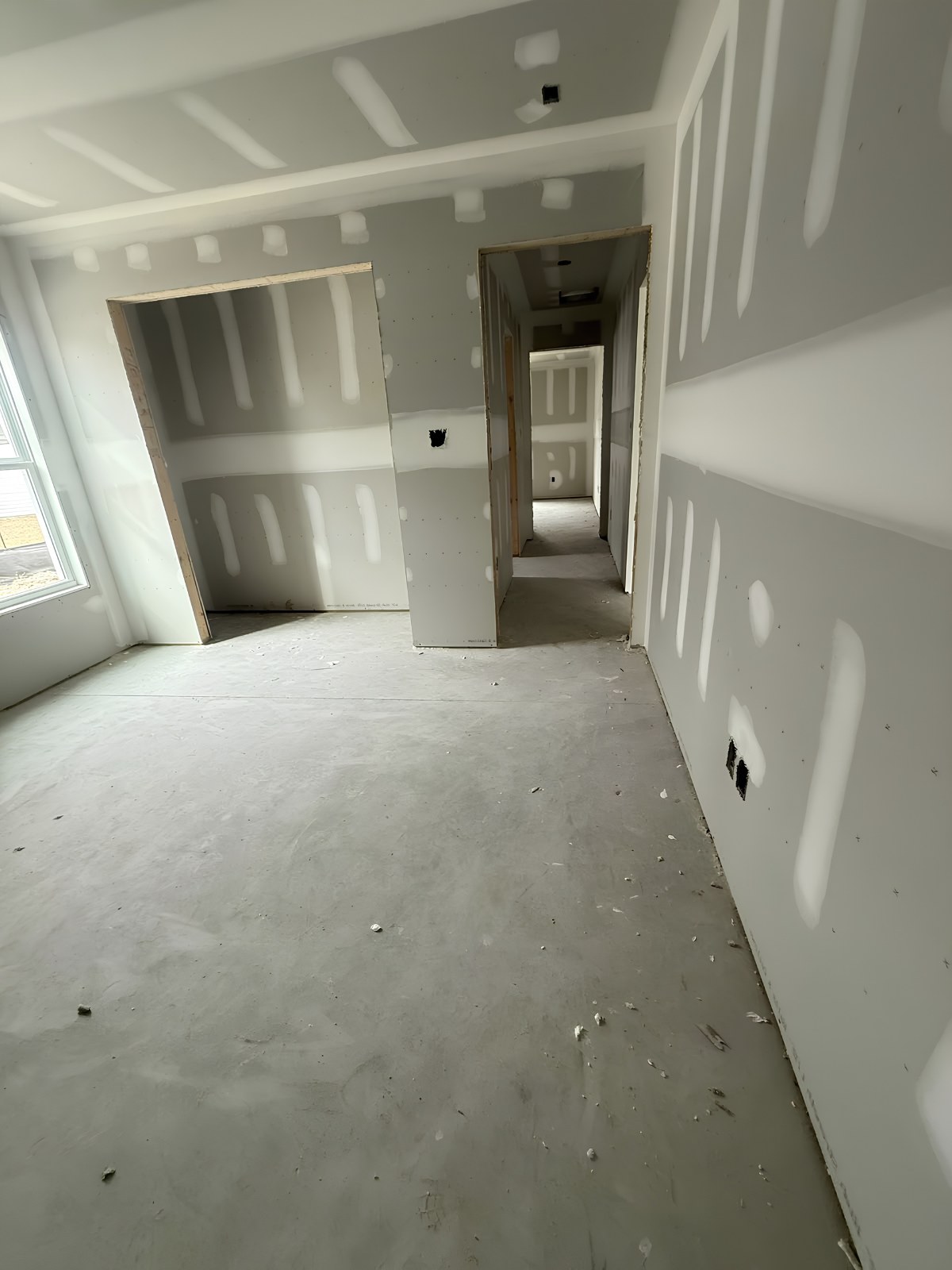 Drywall installation in Haldimand County — new-build room and hallway with seams taped