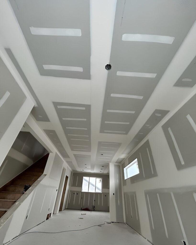 Drywall installed on high walls along a staircase