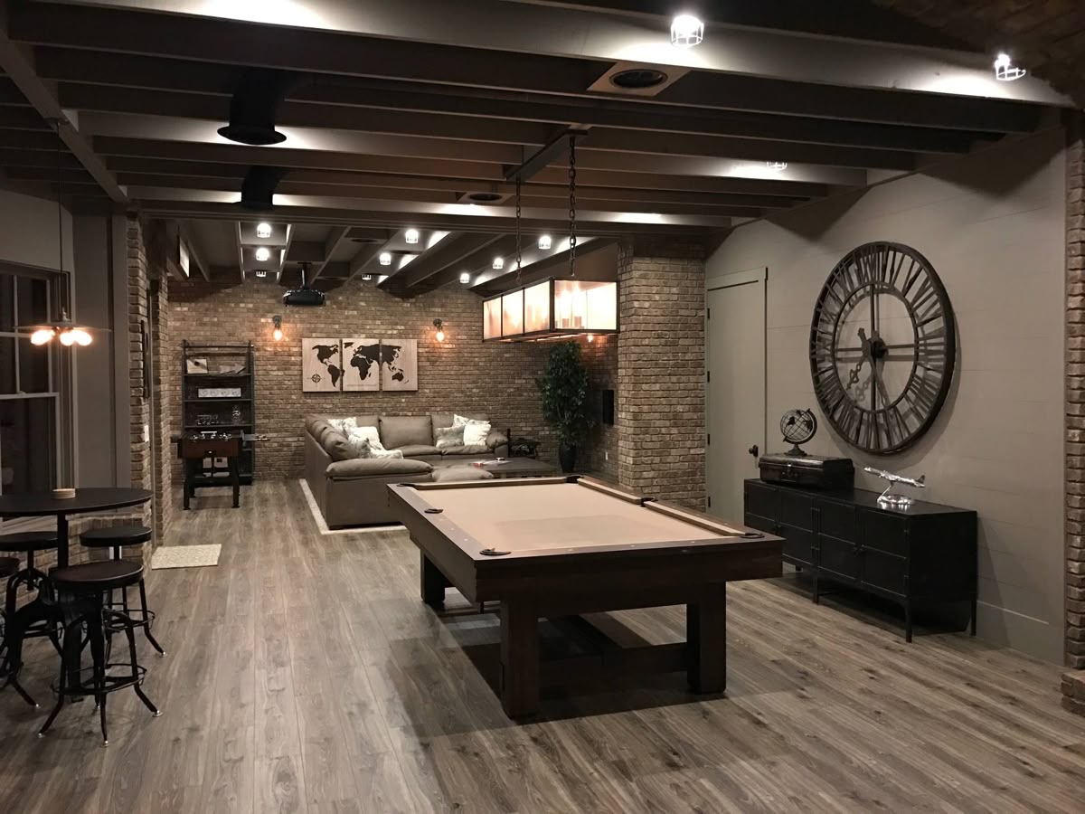 Finished luxury basement lounge with pool table, stone fireplace and reclaimed wood wall