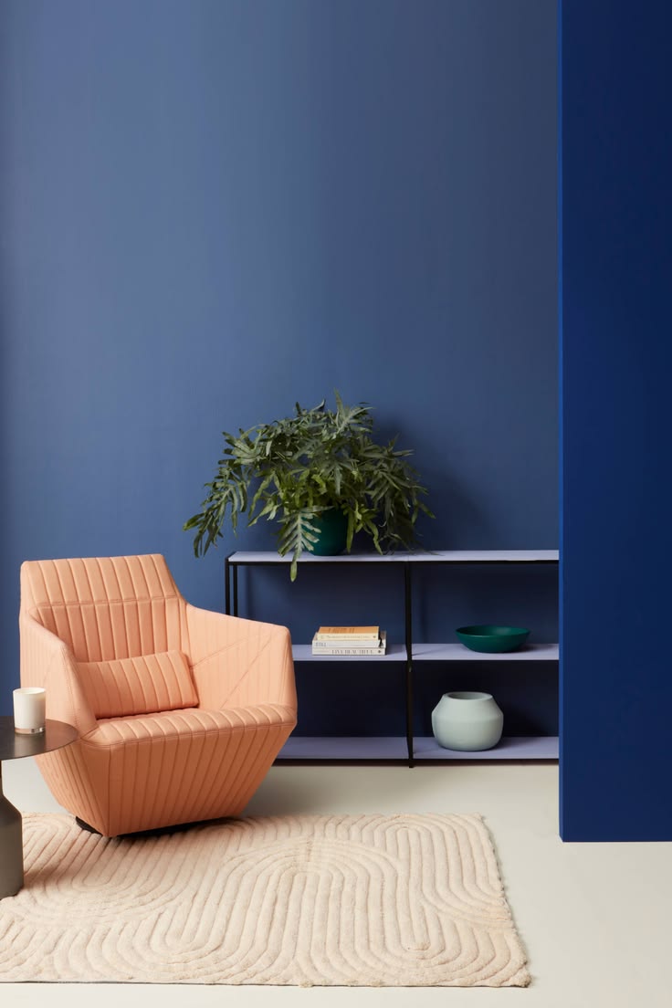Niagara Region interior painting — deep blue wall with a coral armchair