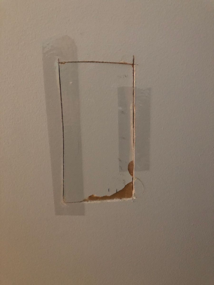 Rectangular drywall access hole cut for repair in a Toronto condo in Toronto