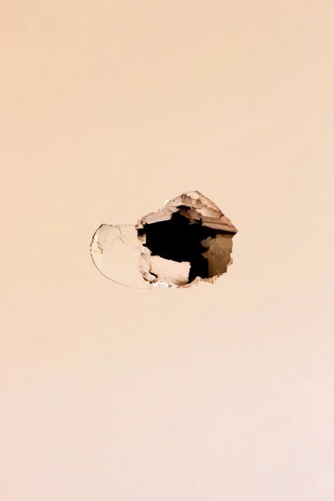Drywall hole with torn paper flap in a Norfolk County cottage in Norfolk County