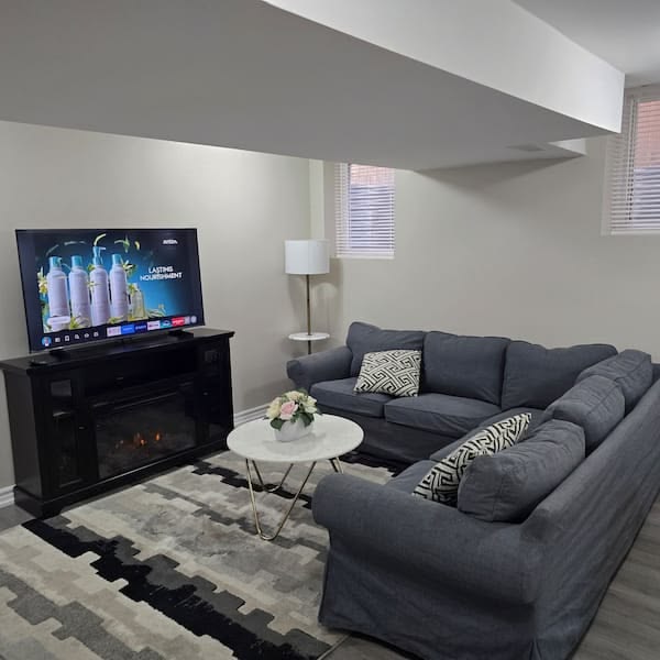 Tenant-ready basement suite lounge with fireplace TV console