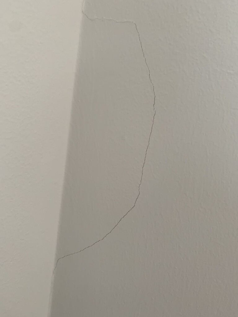Truss-lift crack at a drywall ceiling corner